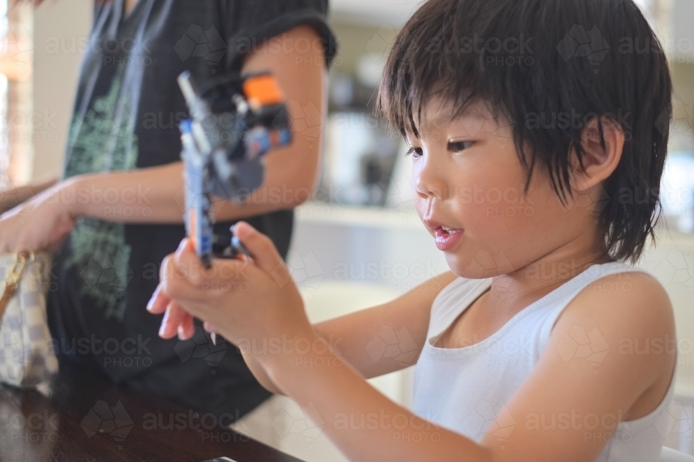 a boy, building a Lego formula race car - Australian Stock Image