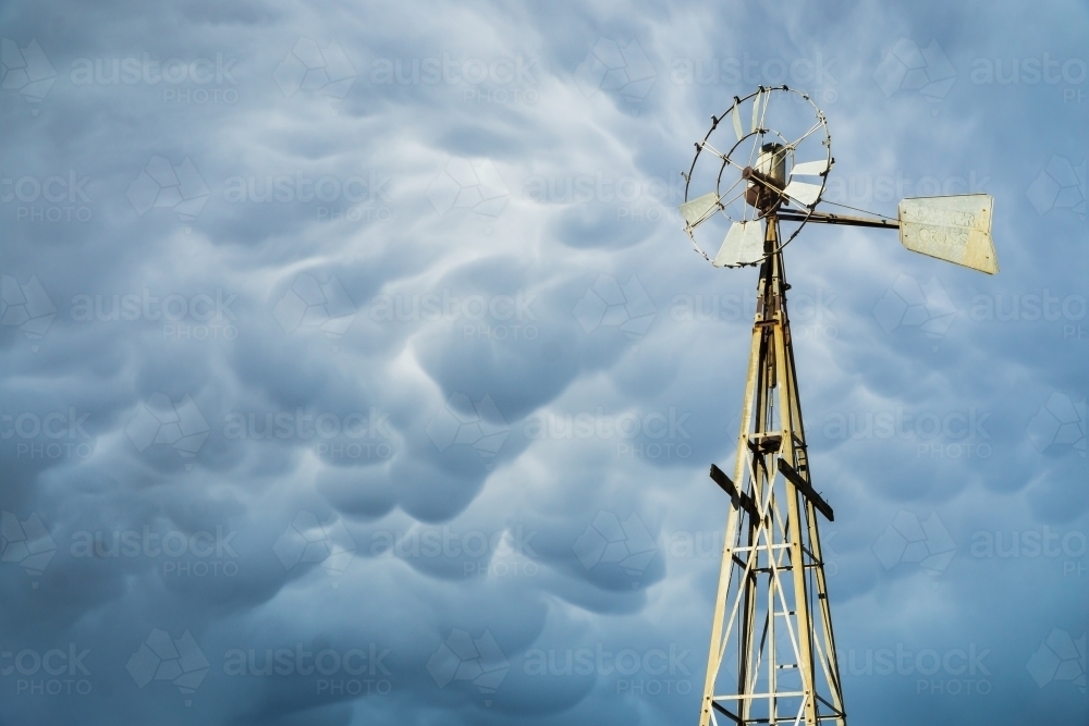 A broken windmill with dark mammatus clouds above - Australian Stock Image