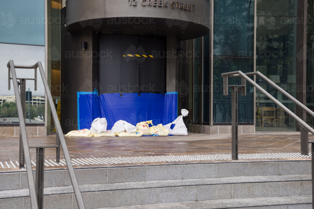 A building entrance is sandbagged and sealed in preparation for tropical cyclone Alfred in Brisbane - Australian Stock Image