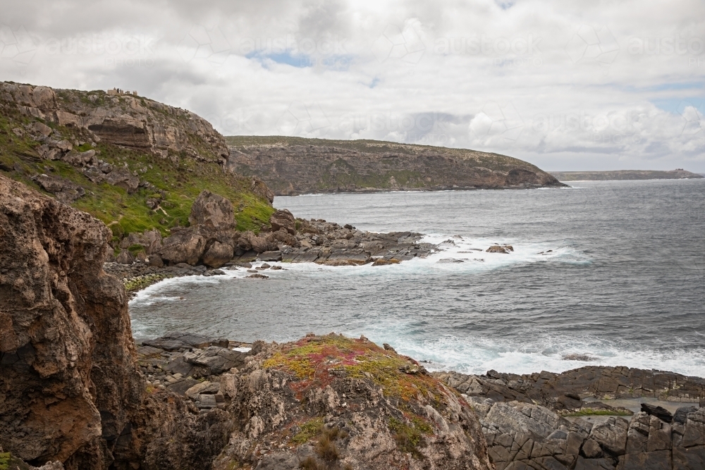 A coastal cliff with ragged waters and jagged rocks - Australian Stock Image