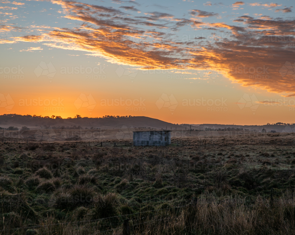 A colourful dawn sky over a country field - Australian Stock Image