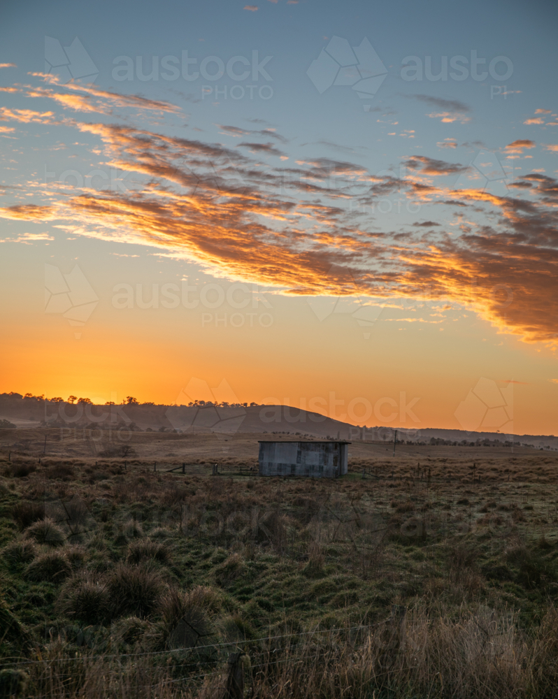 A colourful dawn sky over a country field - Australian Stock Image