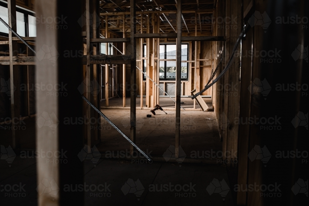 A construction site of a house being built with exposed wires and wooden beams - Australian Stock Image