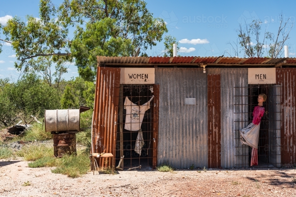 A corrugated iron toilet block in an outback town with signs over the doorways - Australian Stock Image