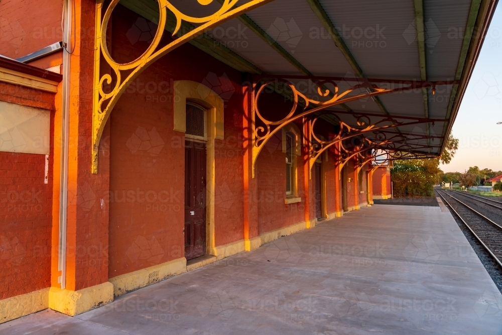 A deserted platform of an historic railway station with ornate veranda trsses - Australian Stock Image