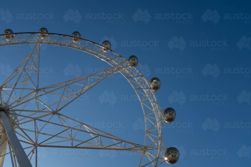 A generic large ferris wheel with gondolas to enjoy the view - Australian Stock Image