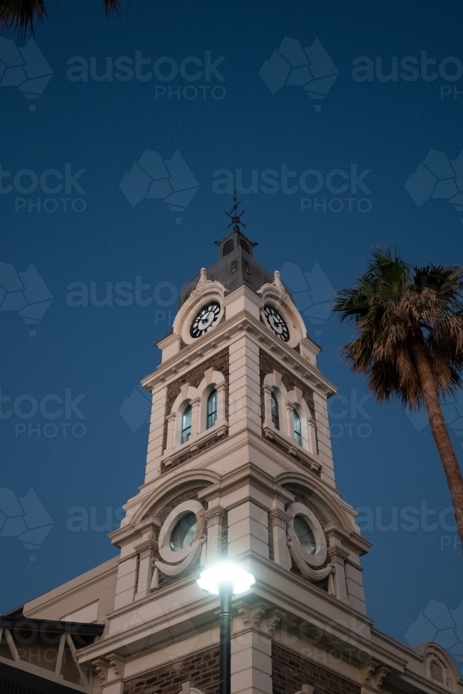 A grand prominent clock tower with palm trees on the sides - Australian Stock Image