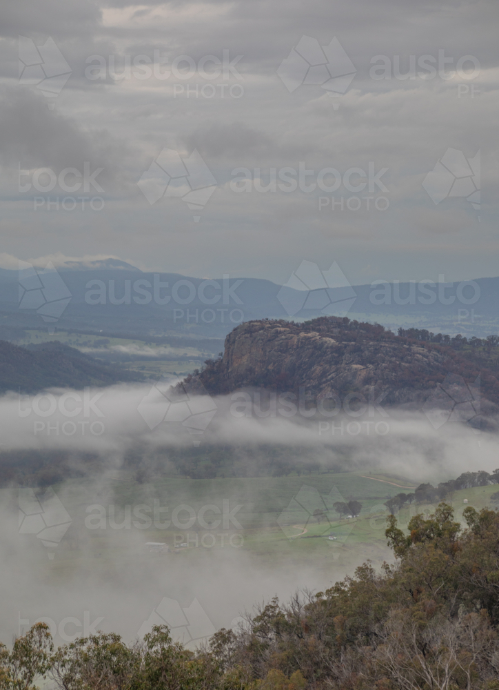 A granite monolith on a misty morning in the country - Australian Stock Image