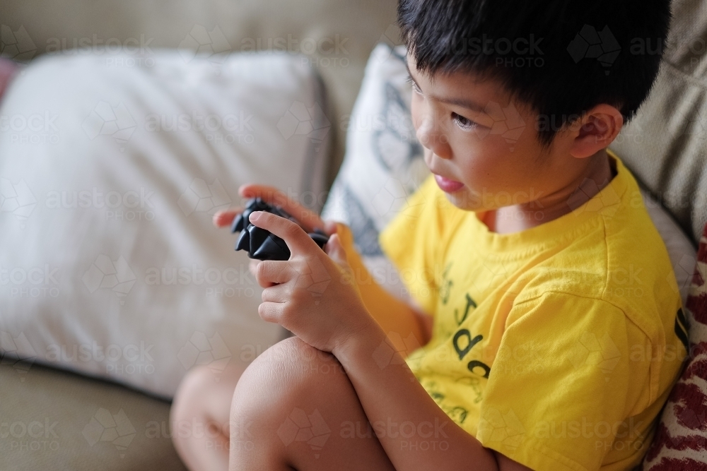 a kid, playing a console game in the living room - Australian Stock Image