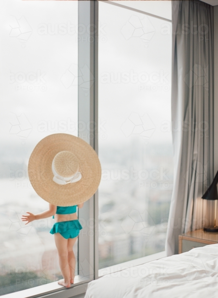 A little girl on holidays wearing french oversized hat looking out into the sydney skyline - Australian Stock Image