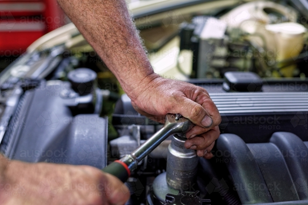 A mechanic servicing a luxury car in his workshop on the Gold Coast - Australian Stock Image