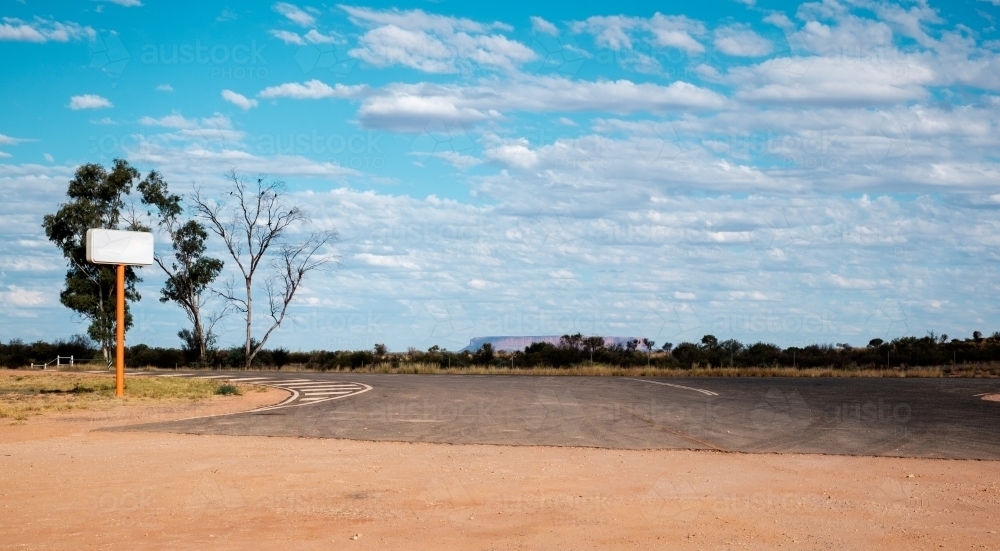 a petrol station sign at the outback with Mount Conner in the horizon - Australian Stock Image