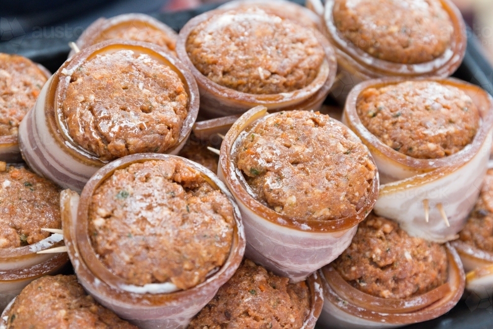 A pile of mini bacon wrapped meatloaf in a tray - Australian Stock Image