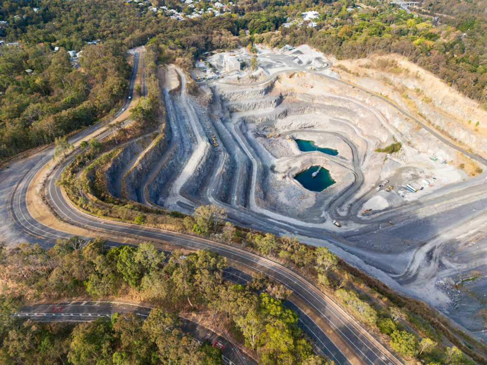 A quarry in the side of Mount Coot-tha with a road wrapping around the quarry - Australian Stock Image