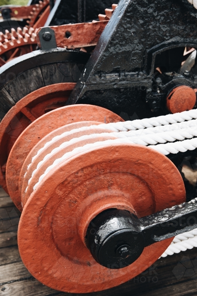 A series of white ropes wound around a large, red wheel or pulley at Old Whaling Station - Australian Stock Image