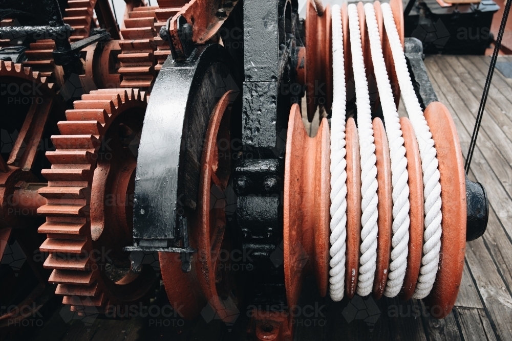 A series of white ropes wound around a large, red wheel or pulley at Old Whaling Station - Australian Stock Image