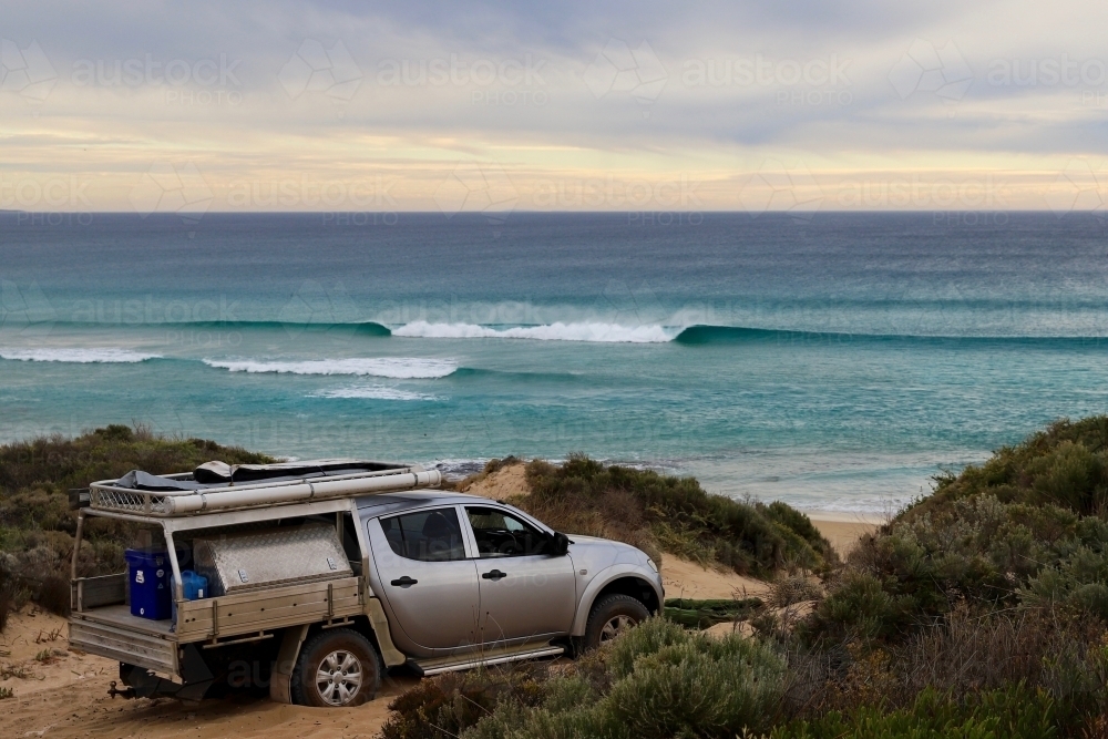 A silver ute bogged in sand on coastal path by seaside - Australian Stock Image