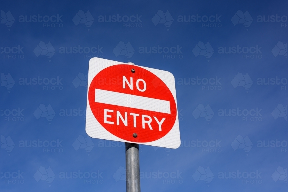 A square red NO ENTRY traffic sign on blue sky background, in Melbourne, Australia. - Australian Stock Image