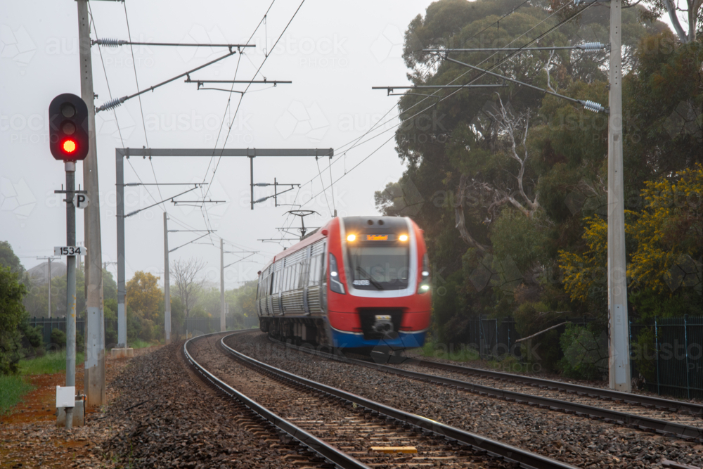 A suburban train on the tracks at Brighton, Adelaide on a foggy day - Australian Stock Image