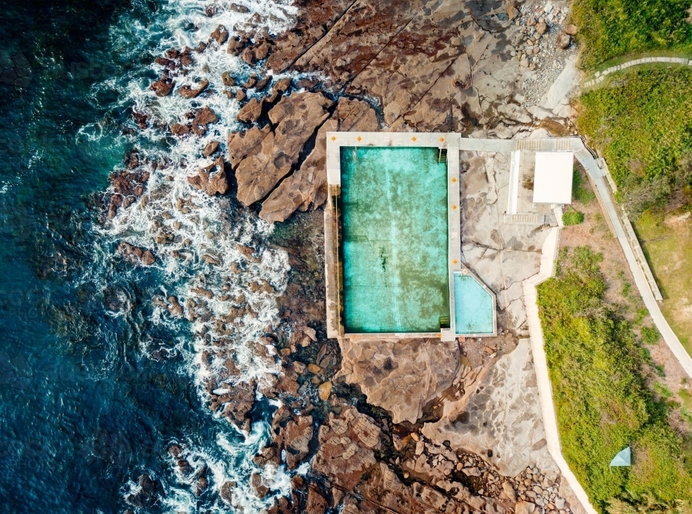 A swimmer doing morning laps of the ocean rockpool at Coalcliff - Australian Stock Image