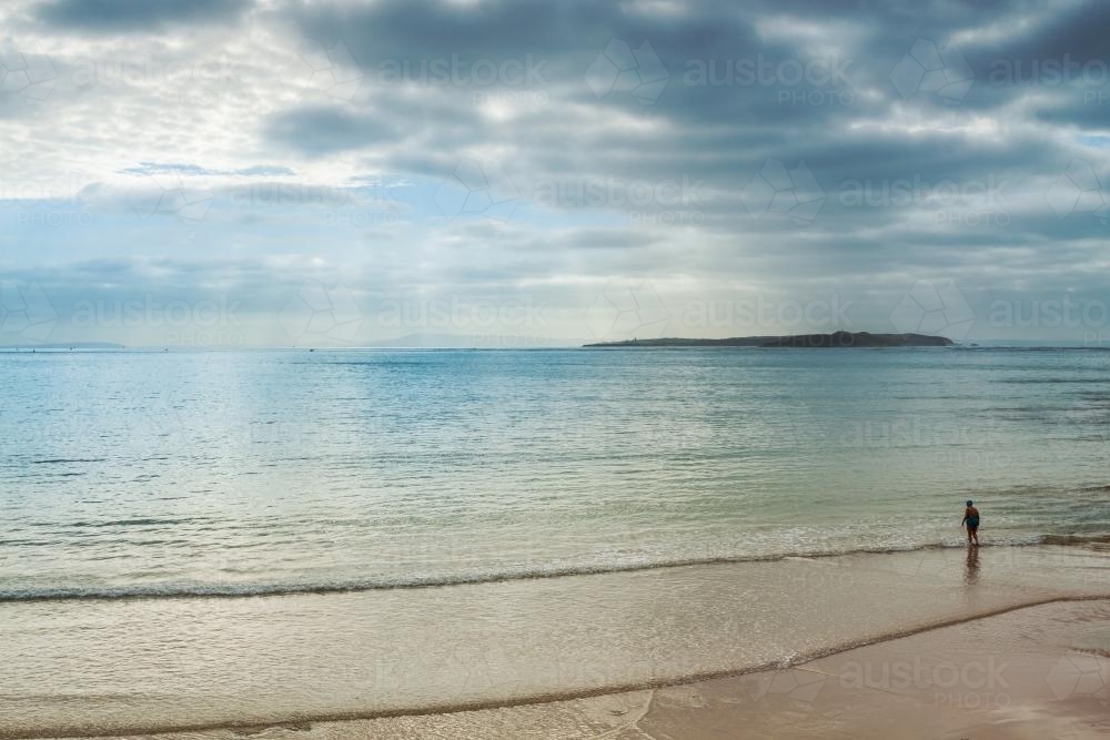 A swimmer walking into the ocean - Australian Stock Image