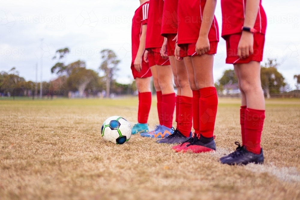 A tween girls football team training together at a sports oval - Australian Stock Image