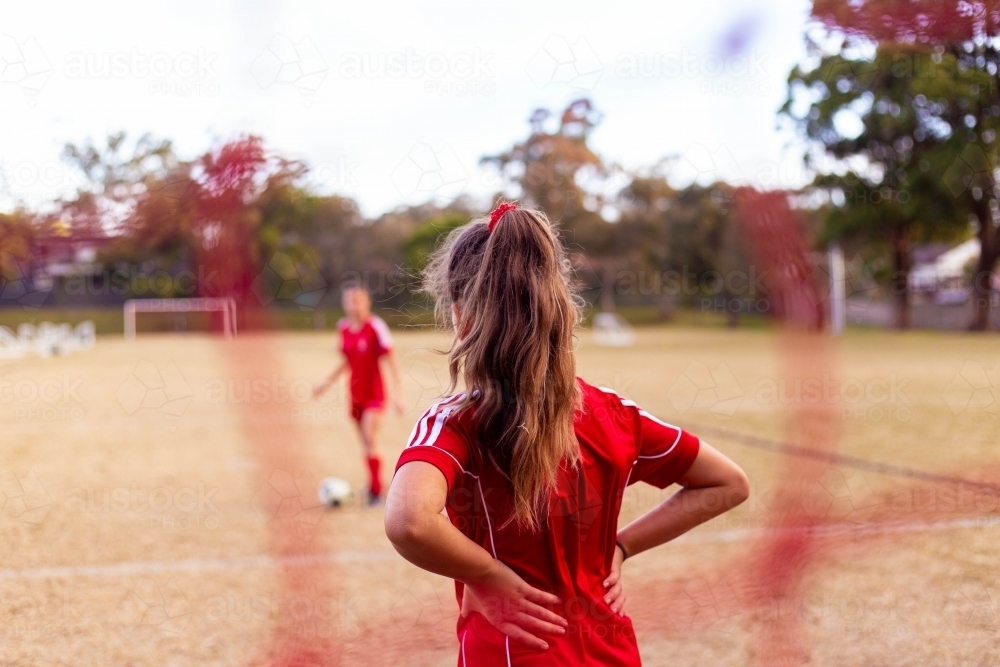 A tween girls football team training together at a sports oval - Australian Stock Image