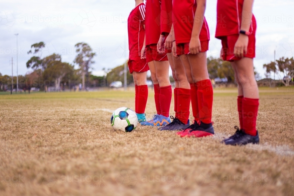 A tween girls football team training together at a sports oval - Australian Stock Image