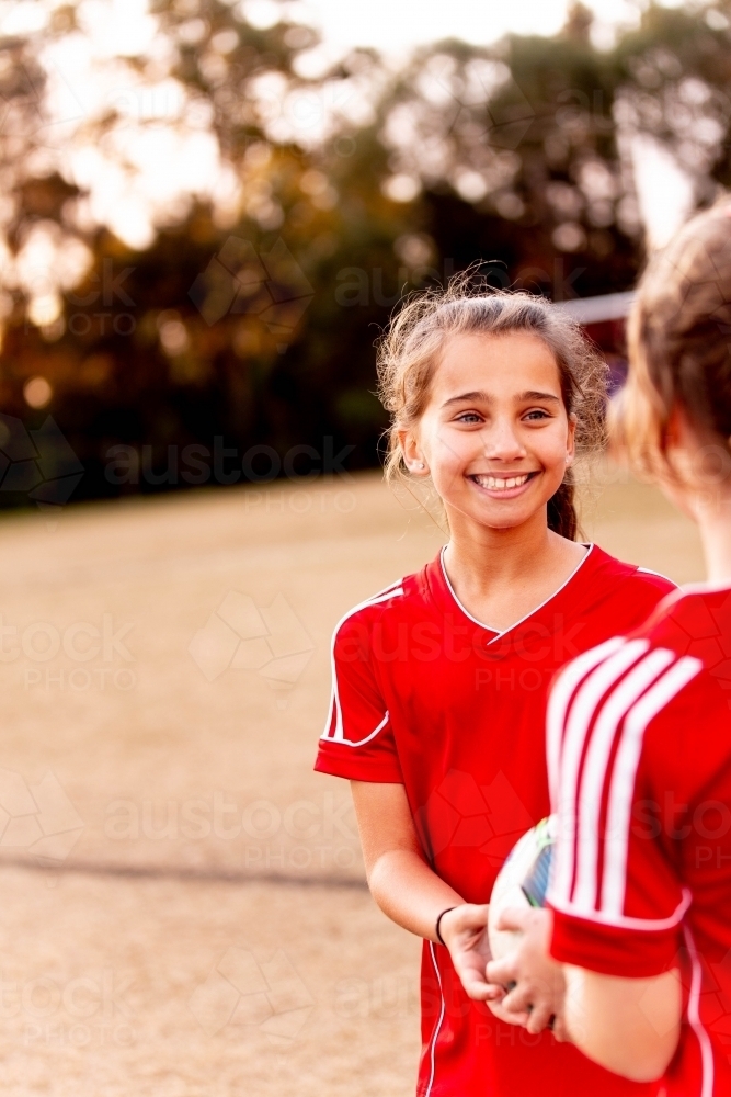 A tween girls football team training together at a sports oval - Australian Stock Image