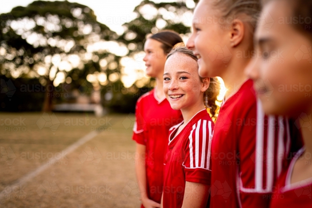 A tween girls football team training together at a sports oval - Australian Stock Image