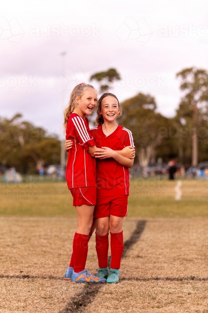 A tween girls football team training together at a sports oval - Australian Stock Image