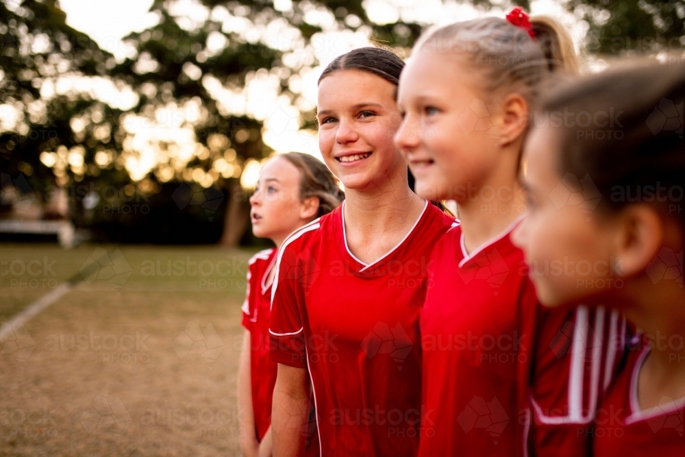 A tween girls football team training together at a sports oval - Australian Stock Image