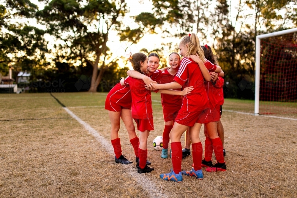 A tween girls football team training together at a sports oval - Australian Stock Image