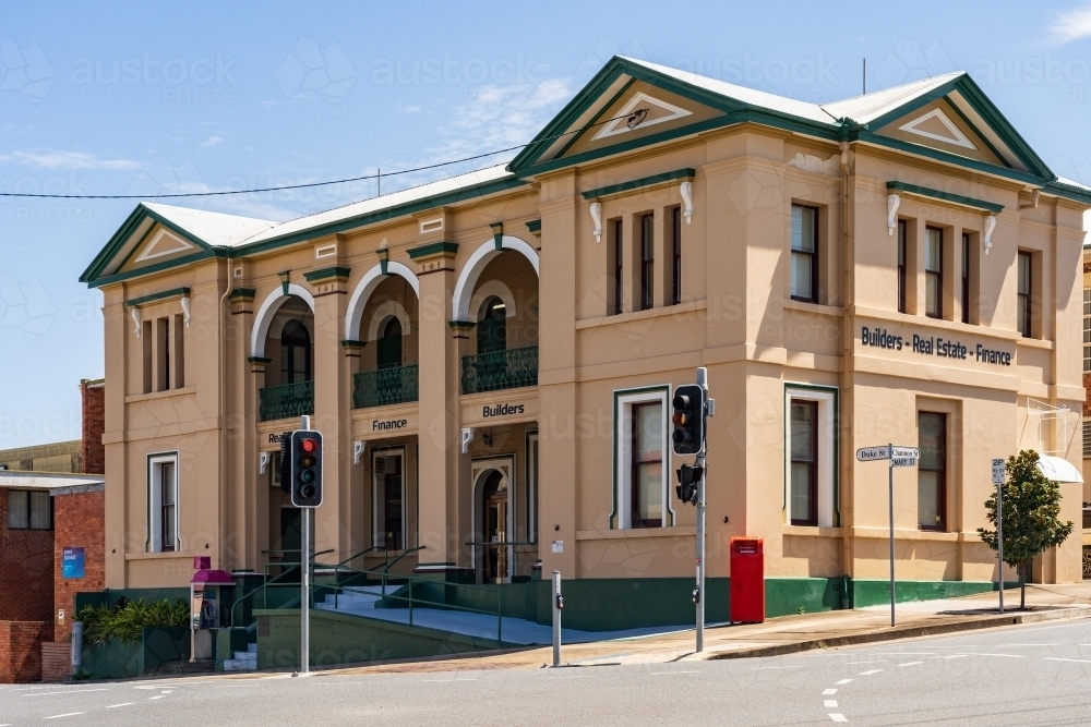 A two story historic building on a sloping corner block with traffic lights in front in Gympie - Australian Stock Image