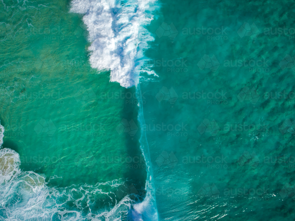 A wall of water is moments away from collapsing over crystal clear water - Australian Stock Image