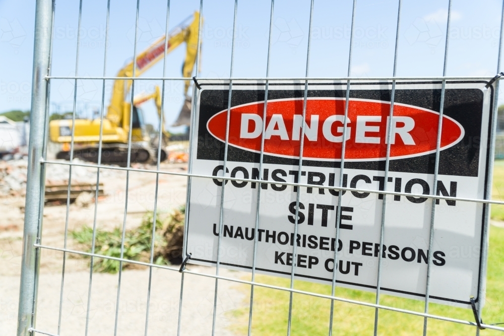 A warning sign on the fence of a construction site - Australian Stock Image