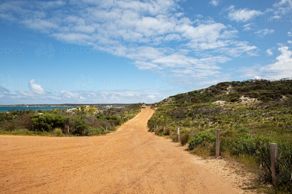 A wide road leading to the ocean that meanders through the shrubs - Australian Stock Image