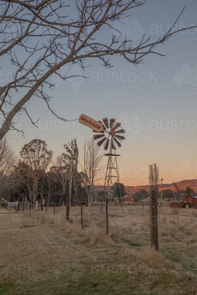 A windmill, a tree and a country scene on a winter morning - Australian Stock Image