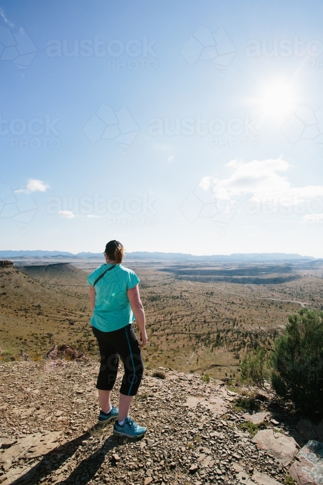 A woman in hiking gear overlooking the rugged landscape of the Flinders Ranges - Australian Stock Image