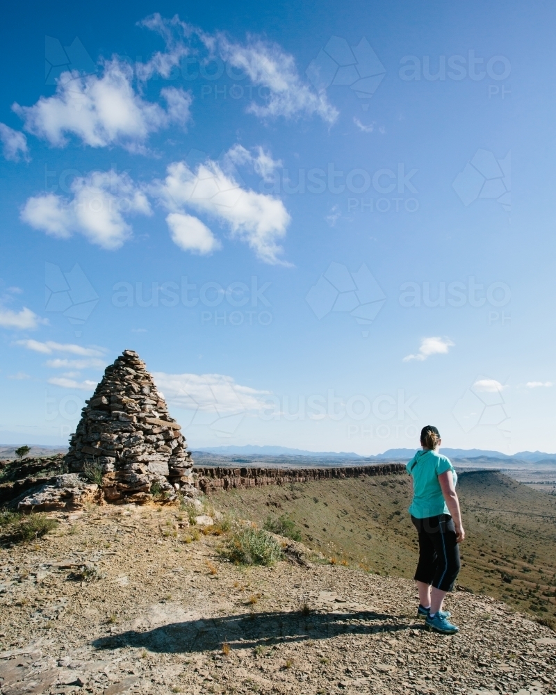 A woman in hiking gear overlooking the rugged landscape of the Flinders Ranges - Australian Stock Image