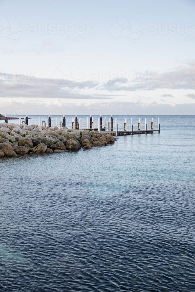 A wooden dock over a pristine calm water - Australian Stock Image