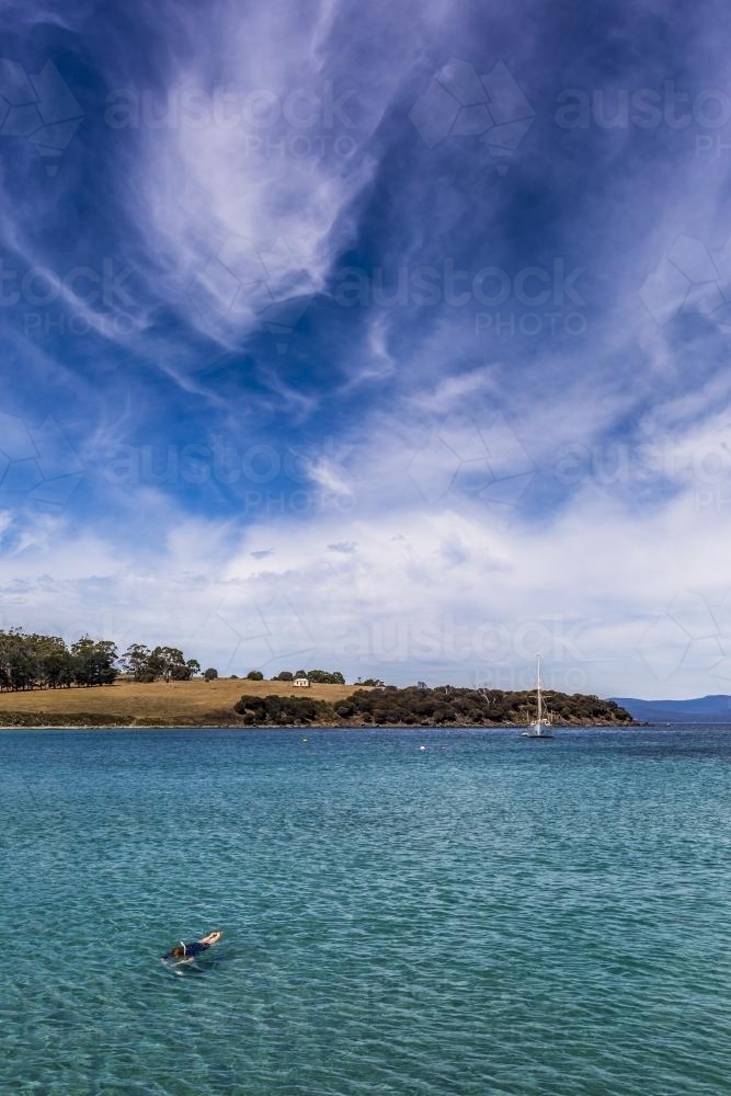 A yacht and snorkeler in the clear water around Maria Island. - Australian Stock Image