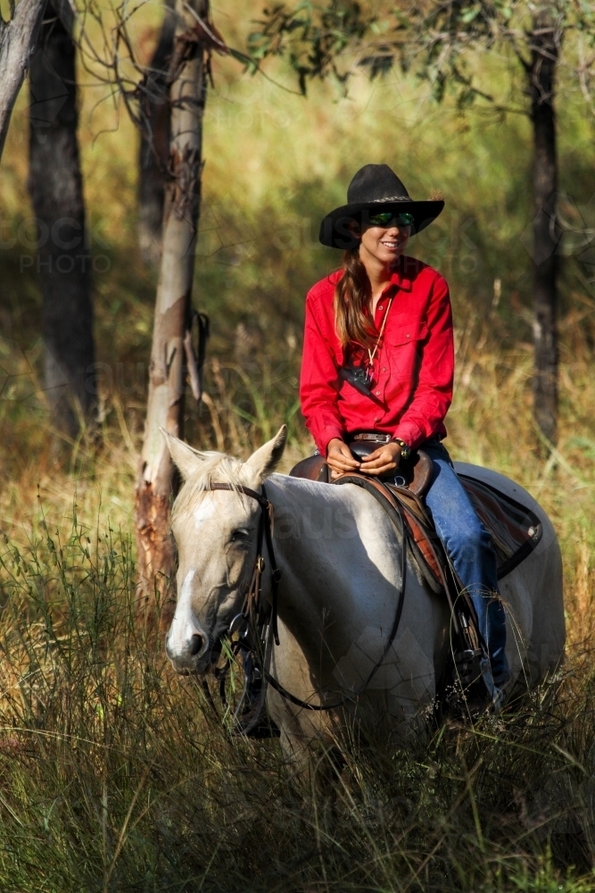 A young country lady riding a horse. - Australian Stock Image