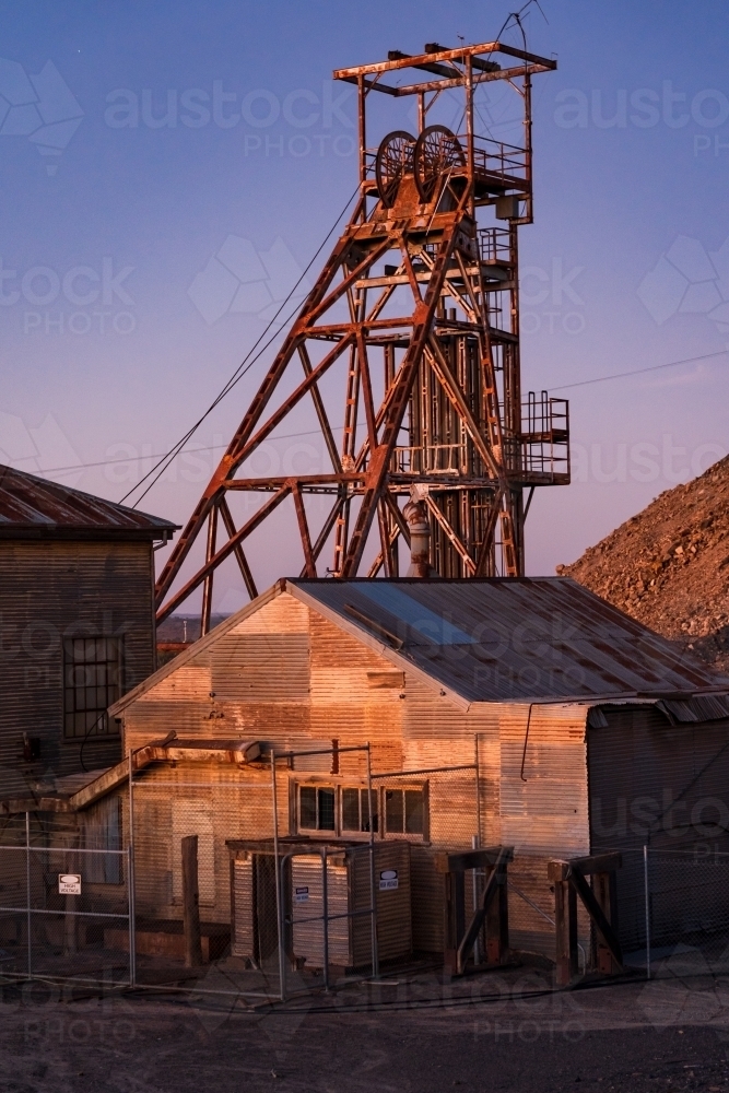 Abandoned sheds and poppet head at a mining plant at twilight - Australian Stock Image