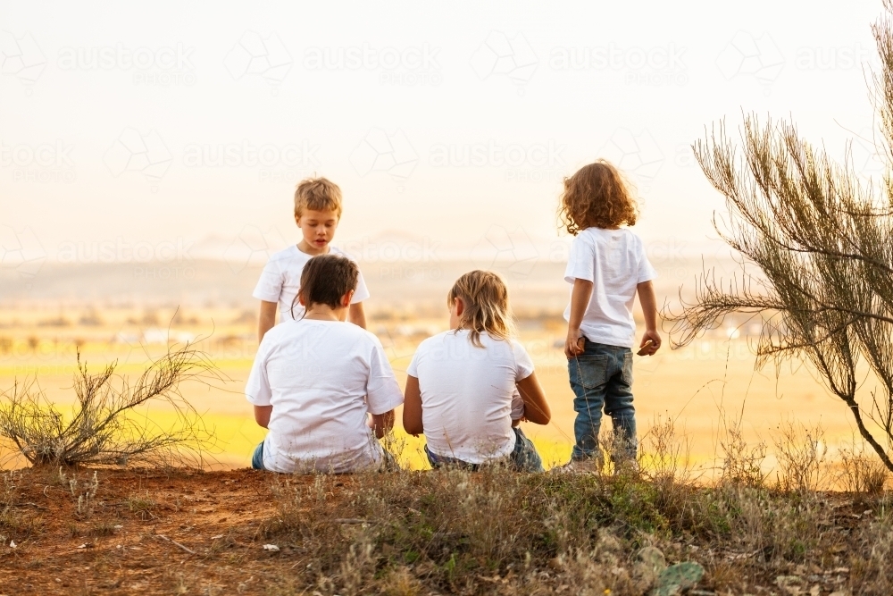 Aboriginal Australian kids play together at top of cliff in country - Australian Stock Image