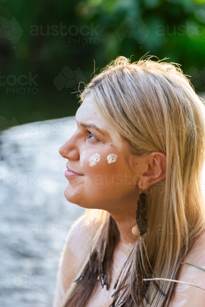 Aboriginal Australian woman on country in traditional dreamtime ochre body paint - Australian Stock Image