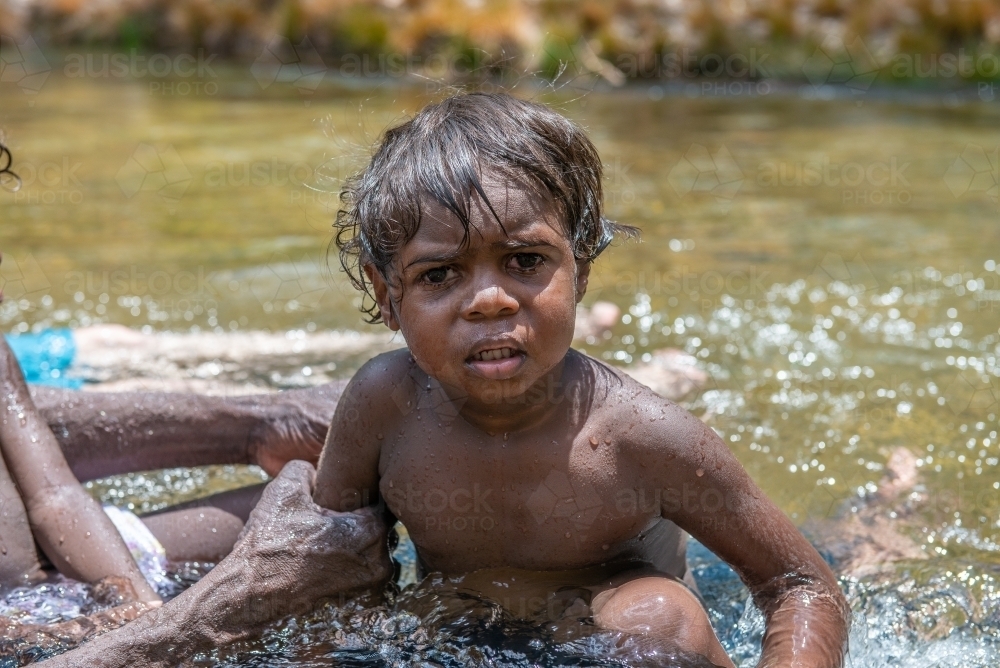 Aboriginal boy in a river - Australian Stock Image