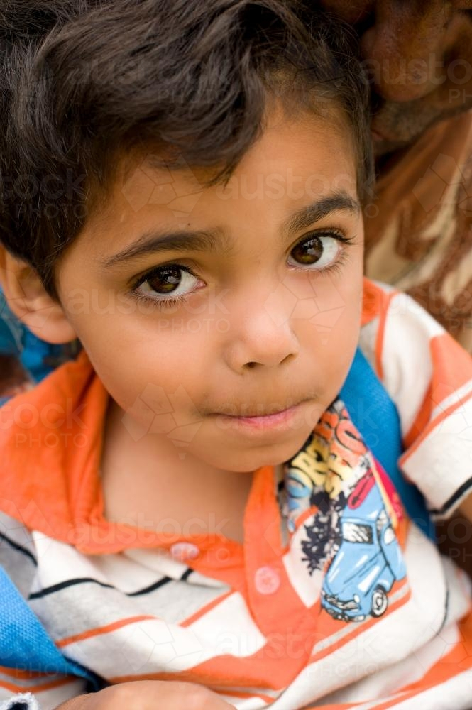 Aboriginal Boy wearing stripe shirt Looking up - Australian Stock Image