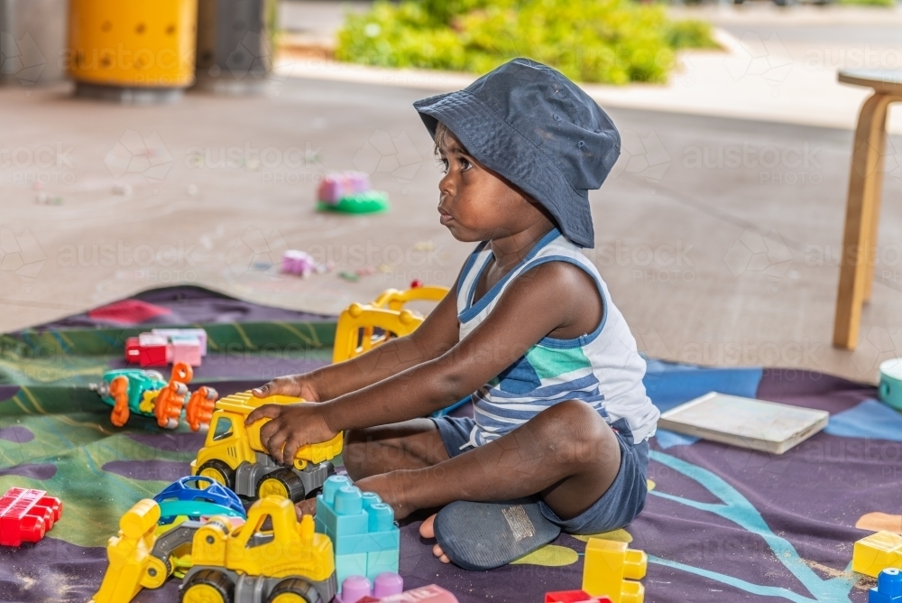 Aboriginal child playing with toys - Australian Stock Image