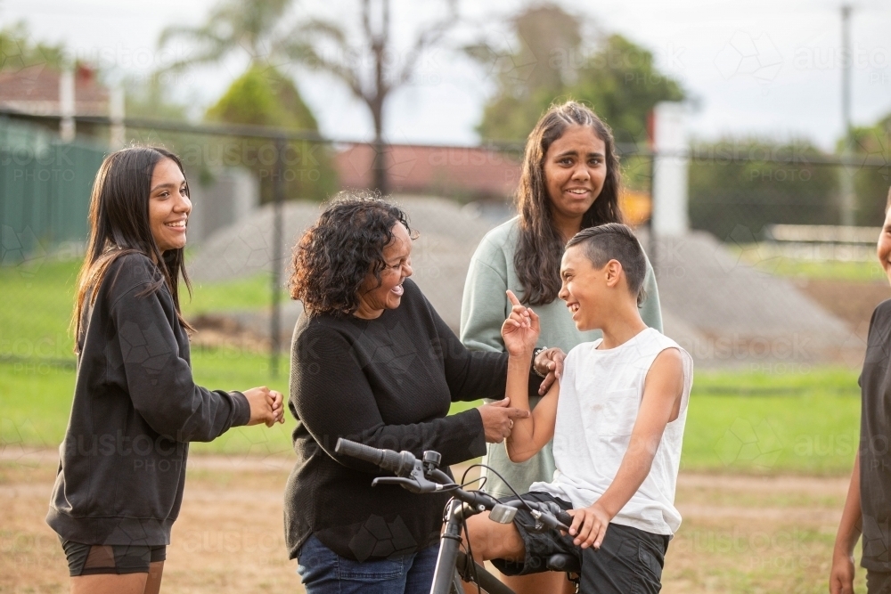 Aboriginal family laguhing and talking outside - Australian Stock Image